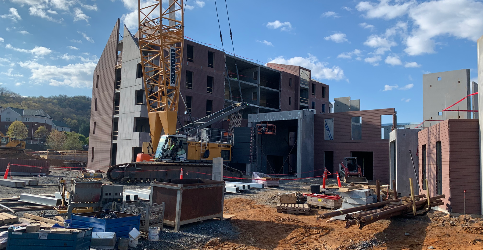 A precast concrete, commercial building undergoing construction with a crane