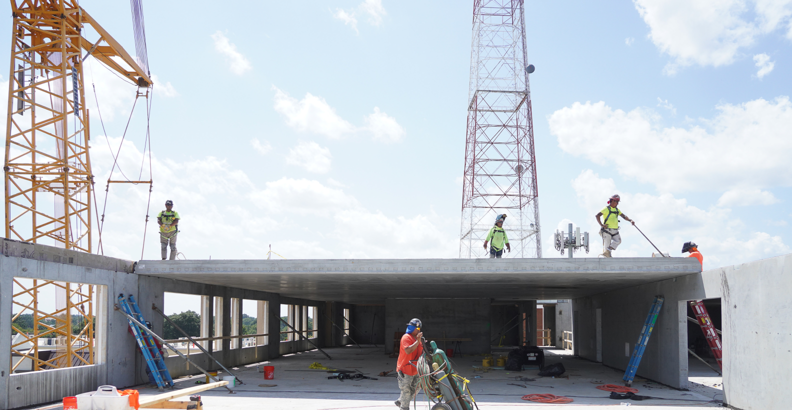 Construction workers assembling precast concrete panels at a construction site.